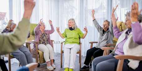 Senioren und Altenpflegerin bei gemeinsame Gymnastik in der Tagespflege