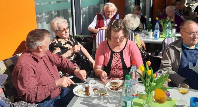 Senioren feiern ein Frühlingsfest auf der Tressase und essen Bratwürste